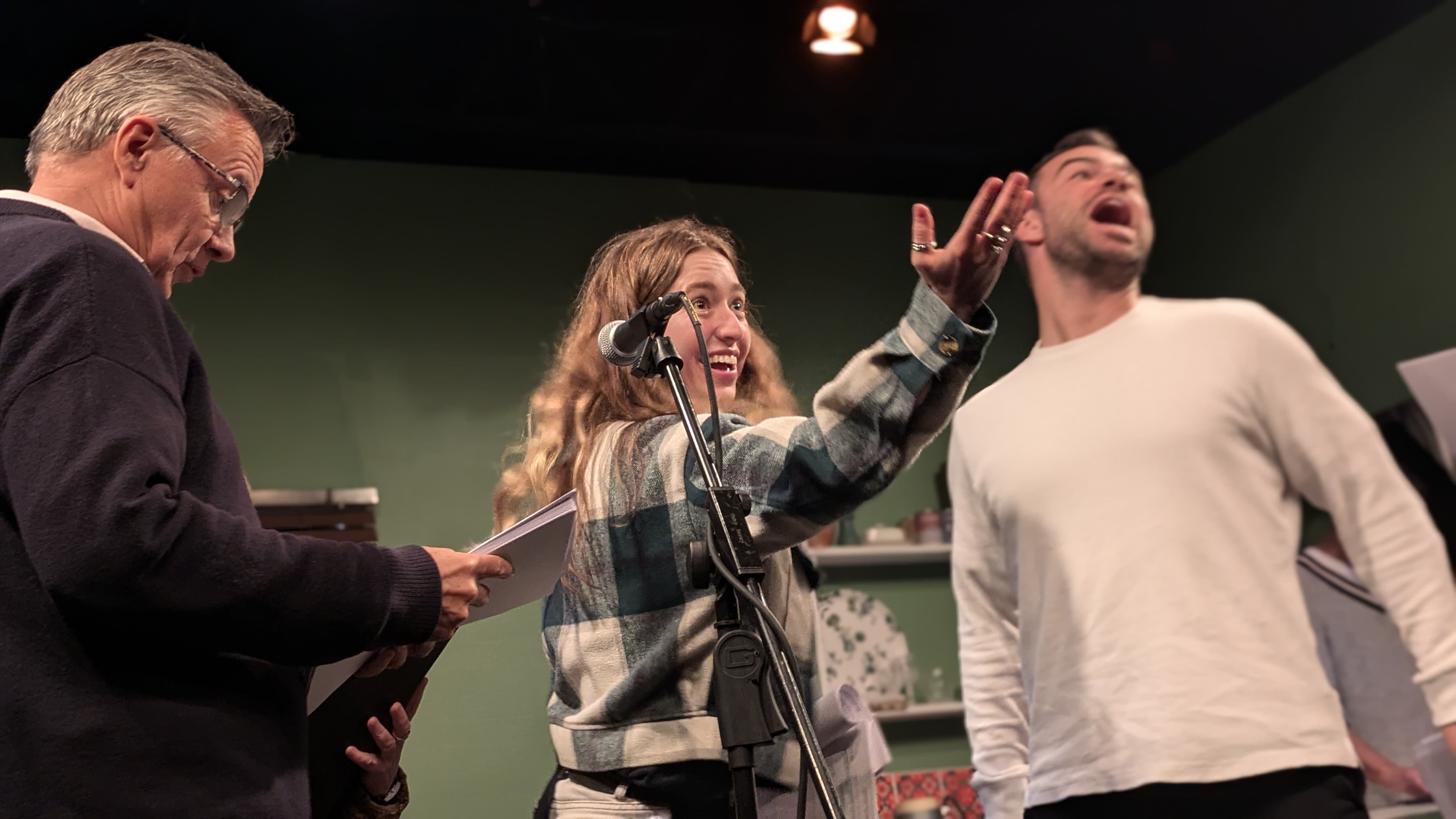 Actors gesture animatedly to the audience